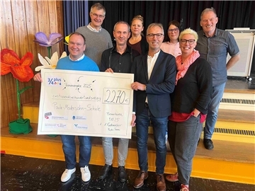 Gruppe lächelnder Erwachsener mit Riesenposter