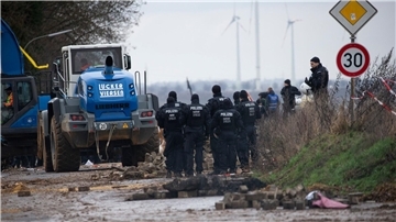 Schwere Räumfahrzeuge entfernen im Beisein der Polizei die von Klimaaktivisten errichteten Barrikaden.