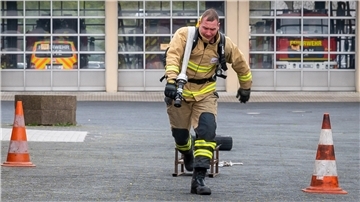 Feuerwehrmann läuft Treppen hoch.