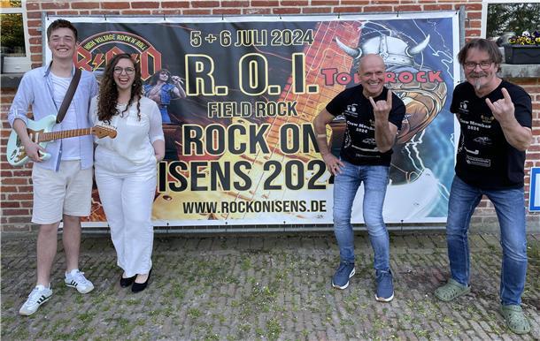 Rock on Isens, drei Männer und eine Frau vor einem Werbebanner