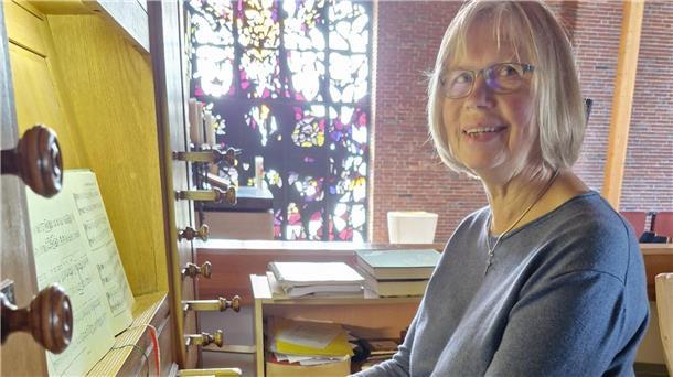 Frau mit Brille an einer Orgel in einer Kirche