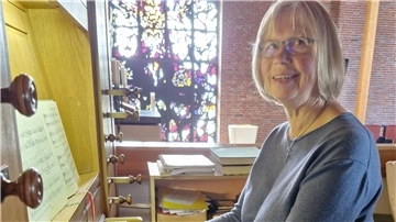 Frau mit Brille an einer Orgel in einer Kirche