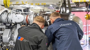 Zwei Techniker arbeiten nebeneinander an einer Antriebsanlage.
