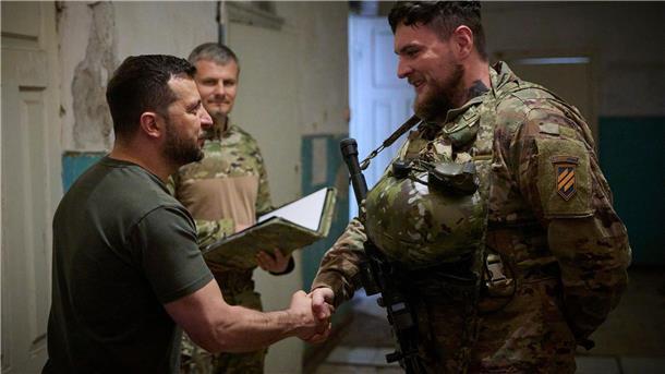 Selenskyj zeichnet einen Soldaten an der Frontlinie aus. Man müsse für jeden Kilometer, den die eigenen Truppen vorwärts kämen dankbar sein, sagte er.