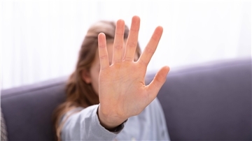 Ein Kind hebt abwehrend die Hand
