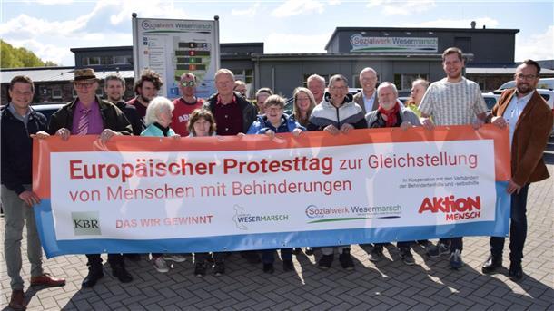 Nordenham: Darum plant das CVJM-Sozialwerk für den 3. Mai einen Protesttag Viele Menschen halten ein Banner.
