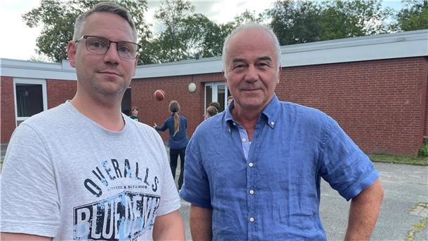 Zwei Männer auf einem Schulhof, Dennis Kittel und Bernd Maibaum von der Zinzendorfschule in Tossens.