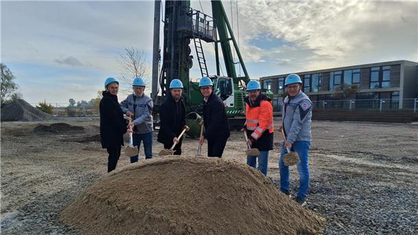 Bild von sechs Personen mit Spaten in der Hand auf einer Baustelle