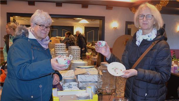 Zwei Frauen halten Porzellan in der Hand.
