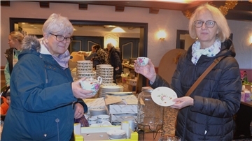 Zwei Frauen halten Porzellan in der Hand.