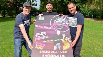 Drei Männer halten ein großes Plakat