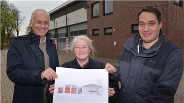 Sie zeigen die Gebäudeansicht mit Anbau des Feuerwehrhauses Rodenkirchen gemäß dem neuen Planentwurf: Architekt Ulrich Bolte, Bauamtsleiterin Wiebke Bruns und Ortsbrandmeister Lars Stratmann (von links).