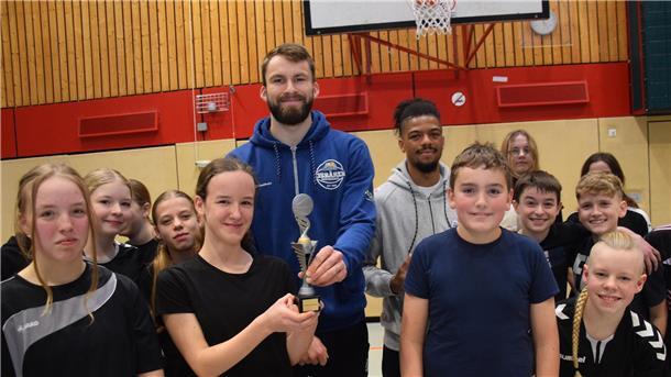 Kinder und zwei Erwachsene mit Siegerpokal