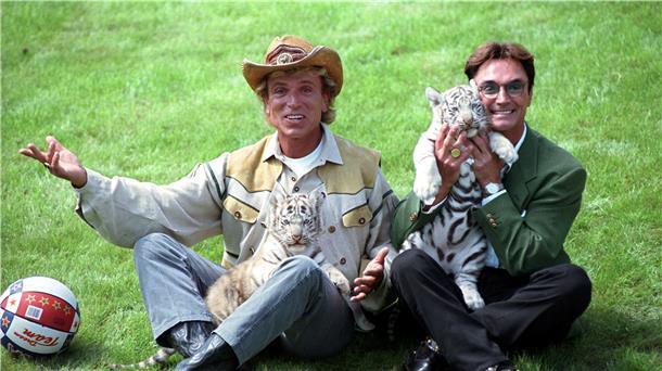 Siegfried (l) und Roy, stellen sich im „Hollywood-Safari-Park" mit zwei weißen Tiger-Jungen den Fotografen vor. Die deutschen Magier sind als „Meister der Illusionen" weltberühmt geworden.