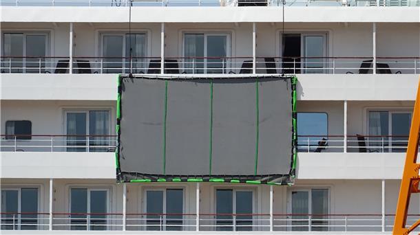 So kommt das Schiff auf den Ozean: Vor einer Kabine hängt ein Bluescreen, auf den später digital das Meer als Hintergrund gespielt wird. Tatsächlich liegt das Kreuzfahrtschiff bei der Lloyd Werft.
