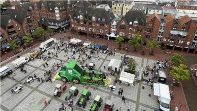 Eine Luftaufnahme zeigt den Nordenhamer Marktplatz mit dutzenden Menschen, Traktoren und Ständen. 