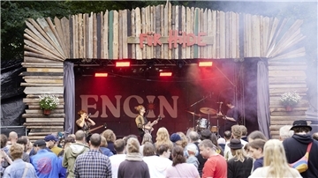 Eine Bühne mit Band und davor Publikum.