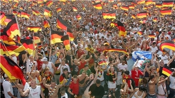 Tausende deutsche Fußballfans schauen zusammen ein Spiel der Nationalmannschaft und schwenken dabei Fahnen