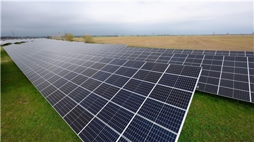 Solaranlagen sind für ein Photovoltaik-Speicher-Kraftwerk auf einer Wiese montiert.