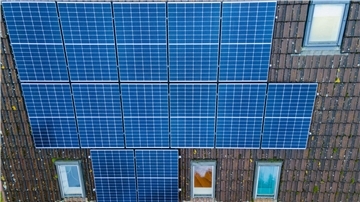 Module einer Photovoltaik-Anlage liegen auf dem Dach eines Privathauses.