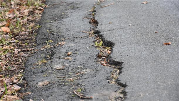 Das Foto zeigt die eingebrochene Asphaltdecke. 