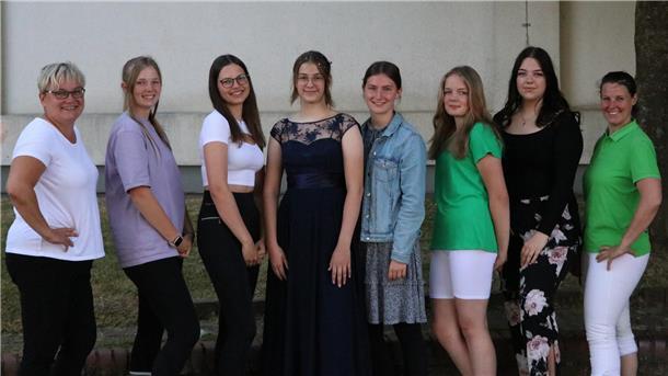 Vladlena trägt ihr neues Abendkleid, umringt von Freundinnen und Klassenlehrerin