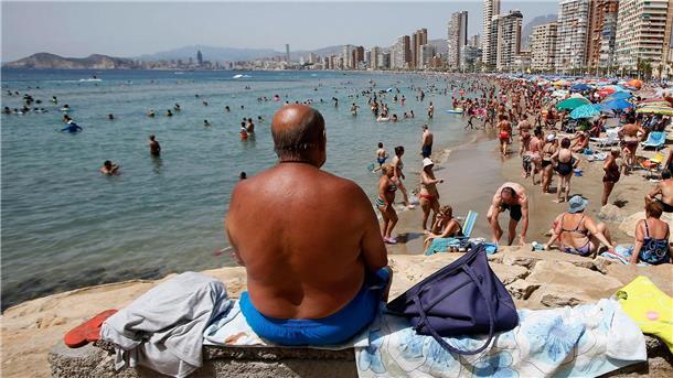 Zwackende Fische nerven Urlauber in Spanien Sonnenhungrige am Strand von Benidorm.