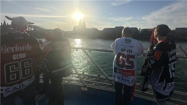 Menschen stehen in Köln auf einem Schiff