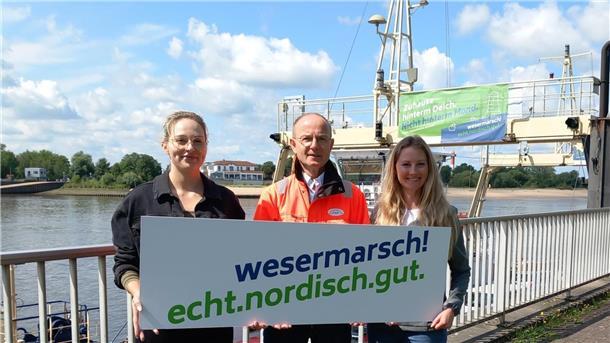 Fachkräfte sollen den Heimathafen Wesermarsch ansteuern Sophia Wolfram (Gemeinde Ovelgönne, Mitglied der Steuerungsgruppe Standortmarketing), Andreas Bettray (Geschäftsführer der Fähren Bremen-Stedingen) und Isa Grube (Wirtschaftsförderung Wesermarsch) präsentieren den Slogan der Kampagne.