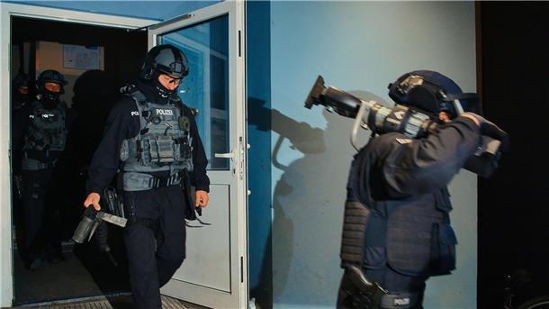 Spezialkräfte verlassen bei einer großangelegten Razzia der Bundespolizei und Landespolizei Brandenburg ein Haus in Weißensee.