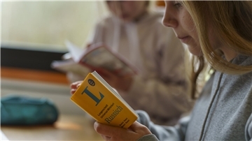 Sofiia (14, Ukraine) lernt beim Unterricht in einer Intensivklasse mit einem Taschenwörterbuch Russisch-Deutsch/Deutsch-Russisch.