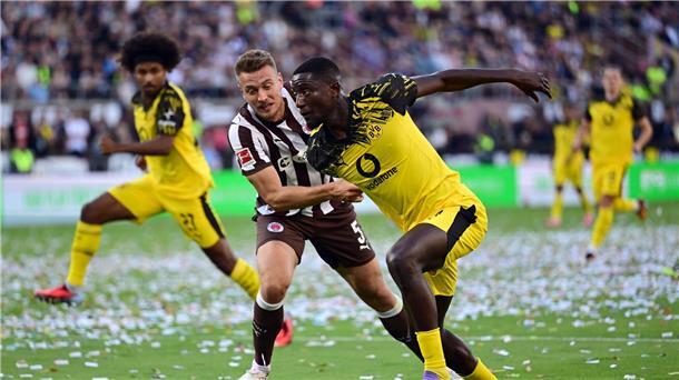 „Tut einfach auf Dauer weh“: BVB hadert nach Doppel-K.o. St. Paulis Hauke Wahl (l) im Zweikampf mit BVB-Stürmer Serhou Guirassy.
