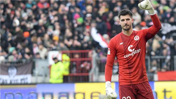 St. Paulis Torwart Nikola Vasilj hebt den Arm. Die Freude über den Sieg ist groß.