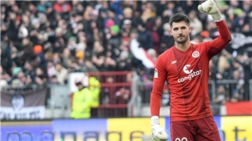 St. Paulis Torwart Nikola Vasilj hebt den Arm. Die Freude über den Sieg ist groß.