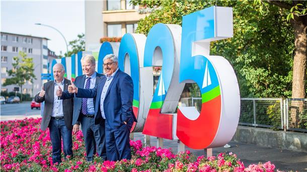 Stadtverordnetenvorsteher Torsten von Haaren (von links), Erlebnis-Bremerhaven-Geschäftsführer Dr. Ralf Meyer und Oberbürgermeister Melf Grantz enthüllten kürzlich den Schriftzug zur SAIL 2025. Ist das wirklich Werbung für die Stadt?