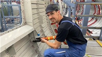 Mann setzt eine Niet in eine Flugzeugschale. Stefan Raetze weiß genau, wie Flugzeuge entstehen. Er ist Strukturmechaniker bei Airbus.