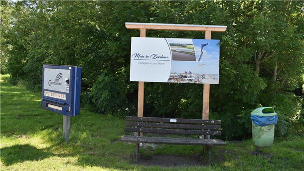 Warum ein Kondomautomat im Nordseebad Burhave für Diskussionsstoff sorgt Kondomautomat und Begrüßungsschild in Burhave.