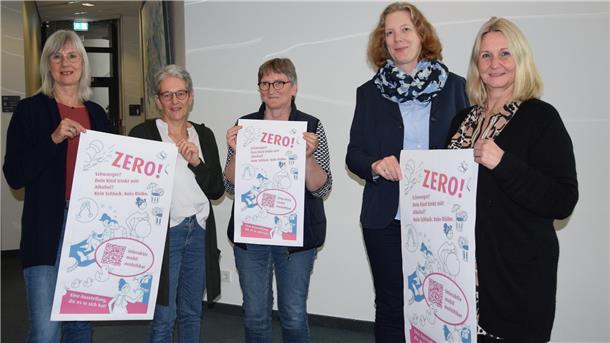 Brake: Ausstellung klärt über Gefahren von Alkohol in der Schwangerschaft auf Mehrere Damen stehen zusammen. Sie halten Poster in der Hand, die auf die bevorstehende Ausstellung "Wenn schwanger, dann Zero!" ab dem 22. April hinweisen.