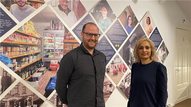 Mann und Frau vor Fotowand