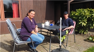 Stephanie Köpke und Mark Meißner sitzen vor ihrem Gartenhaus.