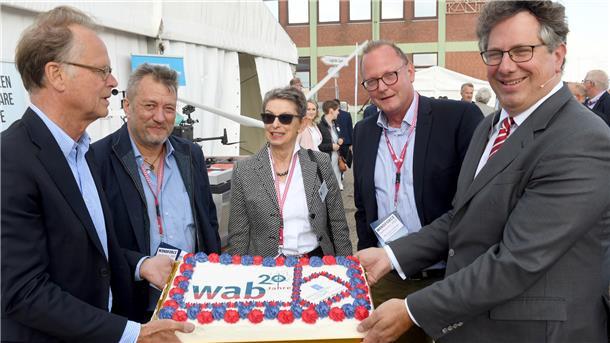 Im Neustart der Windindustrie steckt eine Chance auch für Bremerhaven Stimme der Windindustrie: Vor 20 Jahren wurde das Branchennetzwerk WAB gegründet. Bremerhavens ehemaliger Oberbürgermeister Jörg Schulz (von links), Niels Erdmann (Deutsche WindGuard Offshore), Dr. Rita Kellner-Stoll (damals in den senatorische Umweltbehörde), Wirtschaftsförderer Nils Schnorrenberger und WAB-Vorstand Jens Assheuer halten die Geburtstagstorte.