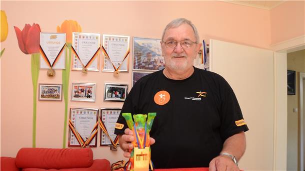 Stolz präsentiert Andreas Kretzer einen Teil seiner Trophäen, darunter den bemalten Glaspokal von den Berlin-Open 2018.