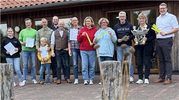 Eine Gruppe Menschen steht vor einem Gebäude.