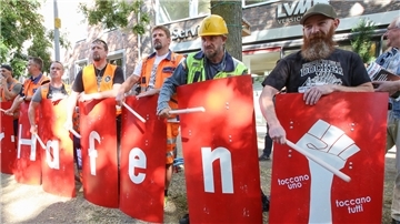 Streikende Hafenarbeiter und Kundgebungsteilnehmer stehen während einer Kundgebung zu den Tarifgesprächen von Verdi und den Hafenbetrieben zusammen. Die Gewerkschaft Verdi und die Hafenbetriebe hatten sich im August nach langen Verhandlungen grundsätzlich auf einen Tarifkompromiss geeinigt.