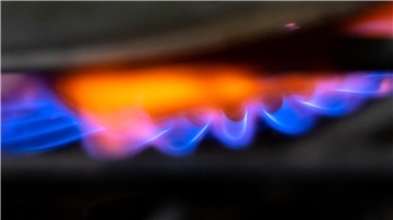 Die Flamme von einem Gasherd ist in der Küche eines Restaurants zu sehen.
