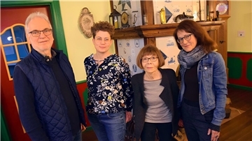 Drei Frauen und ein Mann vor einem Kamin