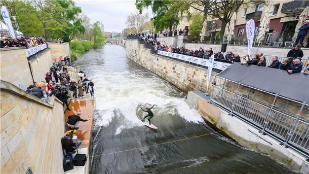 Surfer testen die Leinewelle auf dem Fluss Leine in der Altstadt.