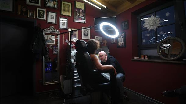 Tattoos nach Brustkrebs - Fast wie die eigene Brustwarze Tattoo-Künstler Andy Engel (r) tätowiert der Brustkrebspatientin Anja D. eine Brustwarze.