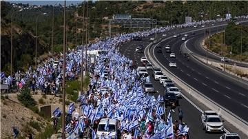 Tausende israelische Demonstranten marschieren entlang einer Autobahn, um gegen die geplante Justizreform der Regierung zu protestieren.