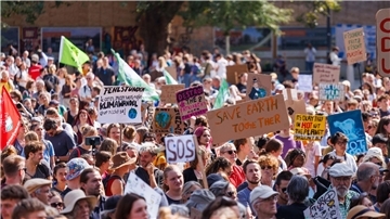 Teilnehmer einer Demonstration gegen den Klimawandel und für Klimagerechtigkeit stehen auf dem Platz der Alten Synagoge in Freiburg.